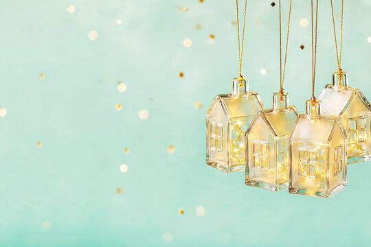 A Christmas background with glass houses and golden glitter. Concept for a cozy family Christmas.