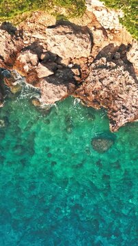 Vertical top down drone view of small boat floating in turquoise Adriatic sea Brela Croatia
