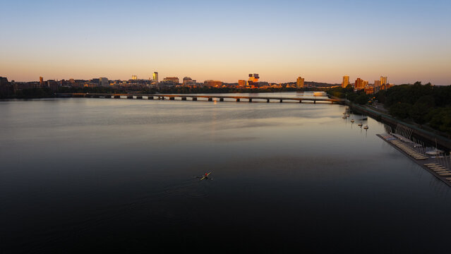Aerial view of a lone rower on the Charles River at sunset with the Boston skyline and Longfellow Bridge in the background, Boston, Massachusetts, United States.