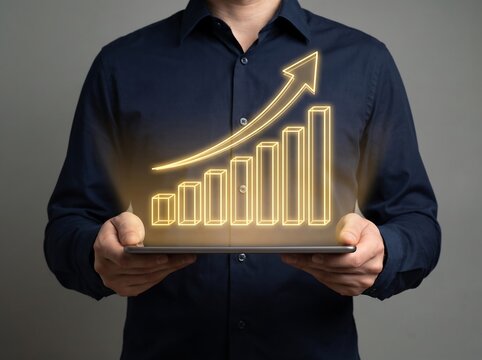 man holding tablet with glowing yellow business graph and arrow