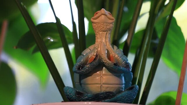 A statue of a frog sitting on top of a bowl, a decorative item for a garden or interior design