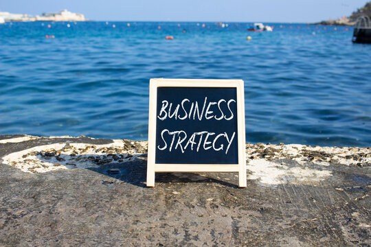 Business Strategy symbol. Blackboard with Concept words Business Strategy. Beautiful sea background. Business and Business Strategy concept. Copy space.