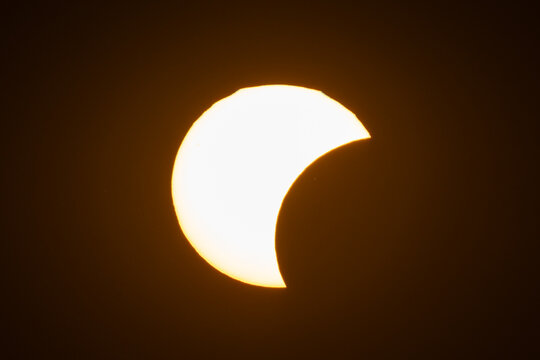 Aerial view of a partial solar eclipse with the moon obscuring part of the sun against a dark sky in Krakow, Lesser Poland Voivode, Poland.
