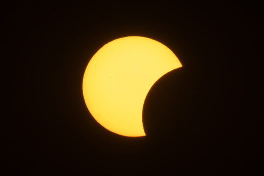 Aerial view of a partial solar eclipse with the moon obscuring part of the sun against a dark sky in Krakow, Lesser Poland Voivode, Poland.