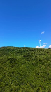 Drone Aerial View Flying Towards Wind Turbines on Mountain Ridge with Dirt Road and Forest at Ivan Sedlo