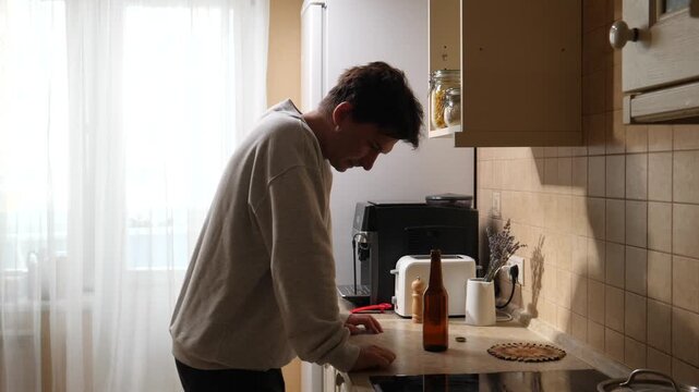 Vertical video man standing in a modern kitchen, viewing a digital recipe on a tablet screen, embodying digital lifestyle and smart home technology while preparing a meal