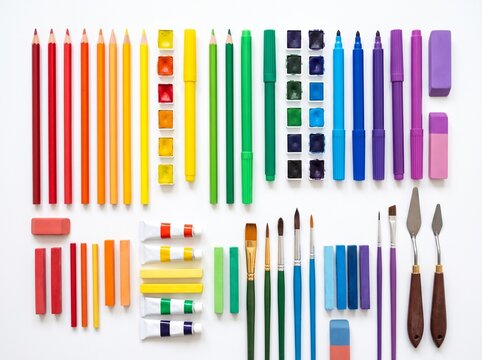 Art supplies laid out in rainbow colors on white background