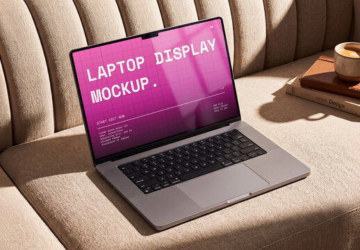 Sunlit Laptop Display Mockup On Textured Sofa With Books And Coffee