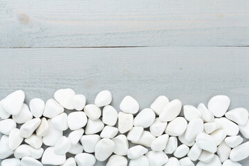 White pebble stones on wooden background, top view © Liami