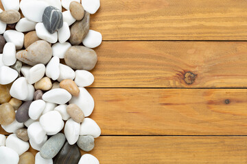 White pebble stones on wooden background, top view © Liami