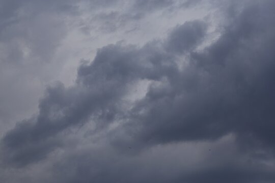 Turbulent dark storm clouds forming in dramatic sky before rain