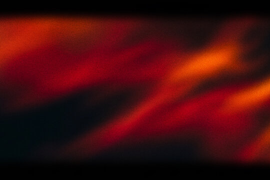 Cinematic light leak overlay with warm red and orange glow, vintage film burn texture on black background, abstract analog light flare effect