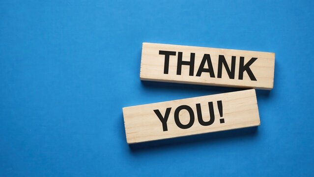 Thank you words written on wooden blocks against a blue background. Ideal for expressing gratitude or customer appreciation in professional marketing campaigns.