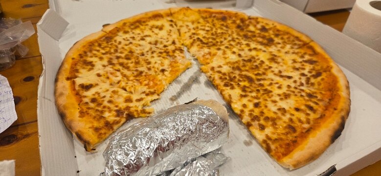 Pizza cortada sobre caja blanca , concepto comida basura