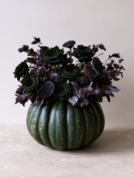 Dark green pumpkin floral centerpiece detailed still life with black rose and dried foliage
