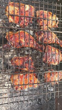 Grilling chicken on a charcoal grill in a backyard