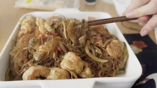 A flavorful homemade dish of translucent glass rice noodles served with juicy prawns and fresh vegetables. The delicate noodles absorb the savory sauce