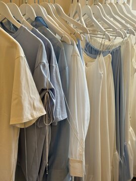 Clothing rack with neatly arranged blue and white garments indoors for fashion or retail concept
