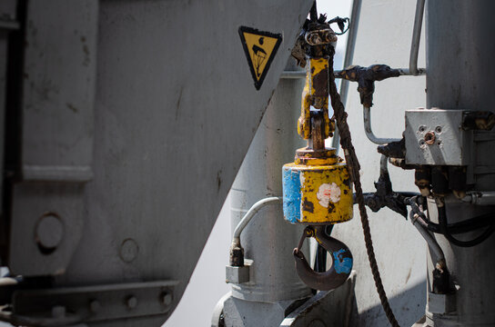 A provision crane hook with the pneumatic control and valve assembly on a background installed on board a vessel. Crane hook shall be regularly inspected and color coded to ensure is reliability