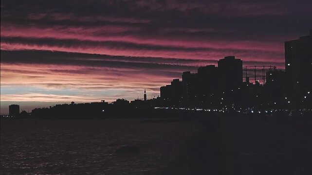 Waterfront boardwalk and avenue with watefront building in montevideo city, under sunset sky