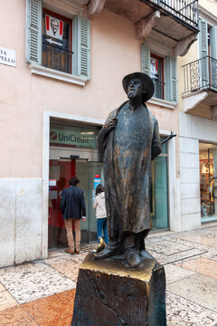 Bronze statue of famous local dialect poet Berto Barbarani standing on European city street