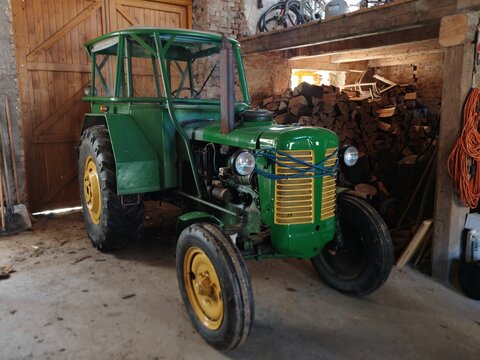 Jihlava,Czech republic-May 2 2026:Restored green vintage ZETOR tractor parked inside a rustic wooden barn