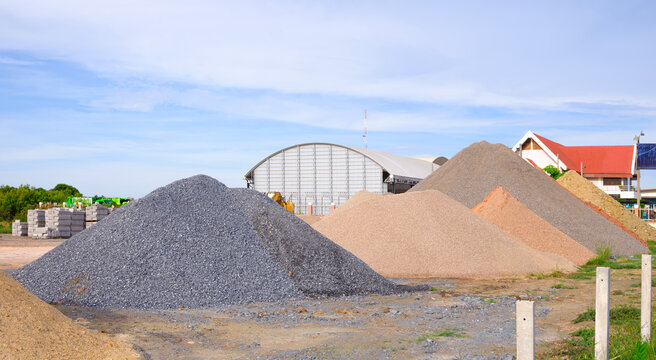 Heaps of sand and various aggregate gravel for construction industry in a building material supply yard on sunny day
