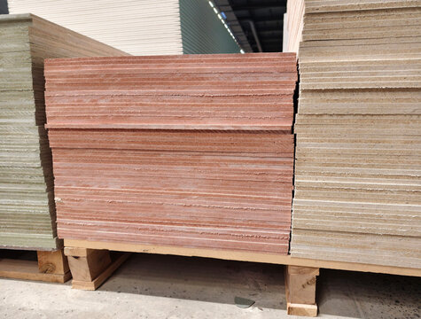 Magnesite building panels stacked in rows inside hardware supermarket with construction sheet material and industrial supply products
