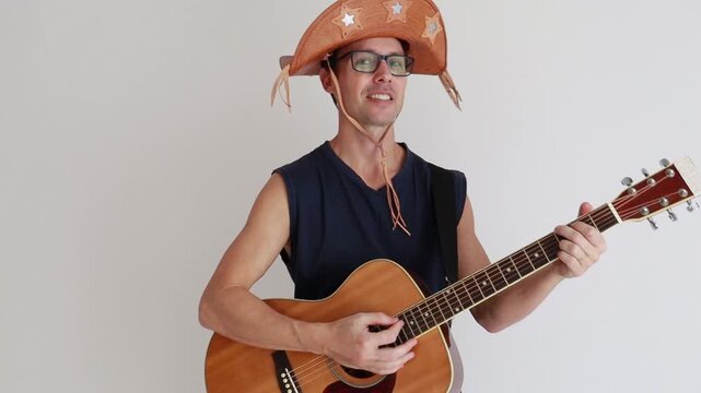 homem musico tocando viol&atilde;o usando ch&aacute;p&eacute;u de nordestino de festa de s&atilde;o jo&atilde;o 