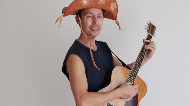 homem musico tocando viol&atilde;o usando ch&aacute;p&eacute;u de nordestino de festa de s&atilde;o jo&atilde;o 