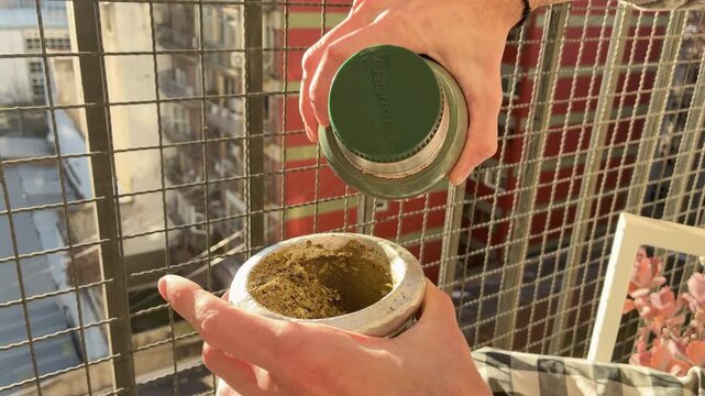 Traditional Argentine Yerba Mate Tea Infusion Warm Drink Lifestyle Scene on terrace, balcony, city rooftop Autumn Day, Latin America. Typical social drink from Argentina, Uruguay, Paraguay and Brazil