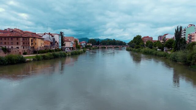 Ebro River in Miranda de Ebro town, Burgos, Spain. Historic stone bridge view and city skyline under cloudy sky. High quality 4k footage