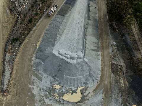 Montrose, Victoria, Australia - 26 August 2026: Aerial view of Boral Montrose quarry featuring large piles of crushed stone, gravel, and heavy machinery operating on dirt tracks.