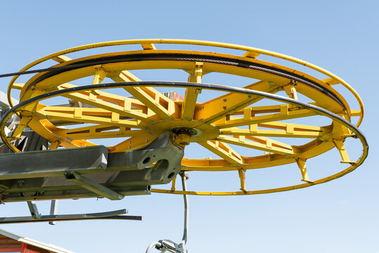 Dolomites, Italy. Yellow cableway pulley wheel and lift infrastructure in the Alpine mountains