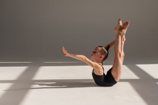 Little gymnast posing on a white background. 