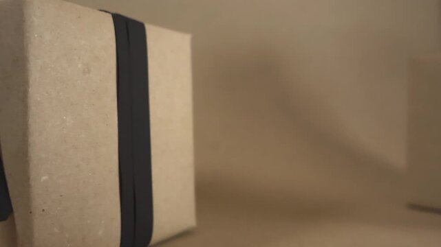 Panning shot of multiple brown cardboard gift boxes with black ribbons and sale tags, perfect for promoting special offers, Black Friday events, or holiday discounts in retail and e commerce
