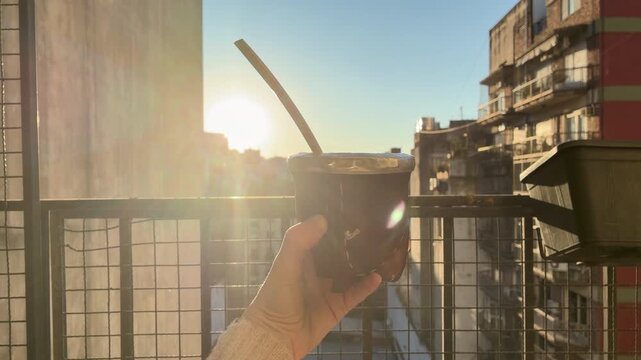 Traditional Argentine Mate Tea Infusion Warm Drink Lifestyle Scene on terrace, balcony, rooftop a Spring Day, Latin America. Typical social drink from Argentina, Uruguay, Paraguay and Brazil
