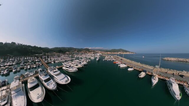 Stunning aerial panorama showing the beautiful tourist port of Varazze. Numerous yachts and sailboats moored at the piers on a sunny day
