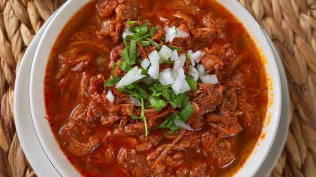 Slow cooked shredded beef birria stew top with fresh cilantro and onions. Mexican food