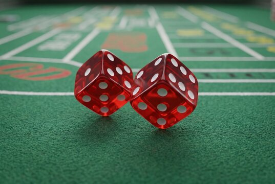Red dice on green craps casino table gambling game winning luck blur
