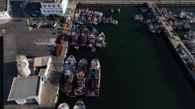 Aerial view of commercial fishing vessels moored along a working quay at Tangier port, Morocco, showing a dense fishing fleet, harbor activity and maritime infrastructure.