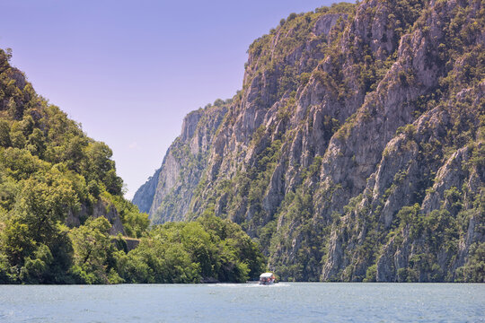 Boats navigating through the scenic Iron Gates gorge on the Danube River, surrounded by towering cliffs