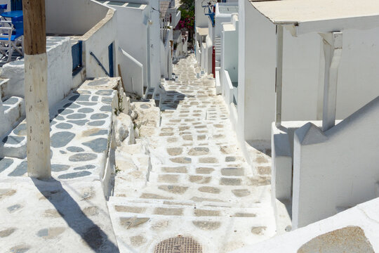 Mykonos island alley with whitewashed architecture and cobblestone path