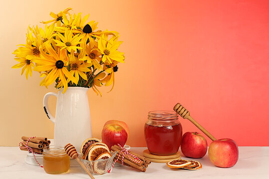 Autumn banner with a beautiful bouquet of rudbeckia in a vase, honey, apples, dried orange, cinnamon and star anise on an elegant background, autumn greeting and gratitude concept, cozy composition