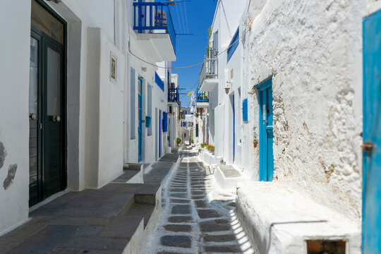 Mykonos island alley with traditional white buildings and blue details