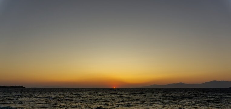 Mykonos sunset over the Aegean Sea with fading light