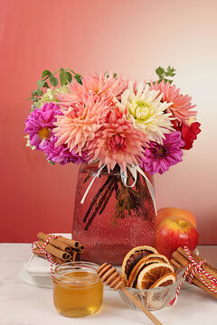 Autumn banner with a beautiful bouquet of dahlias in a vase, honey, apples, dried orange, cinnamon and star anise on an elegant background, autumn greeting and gratitude concept, cozy composition