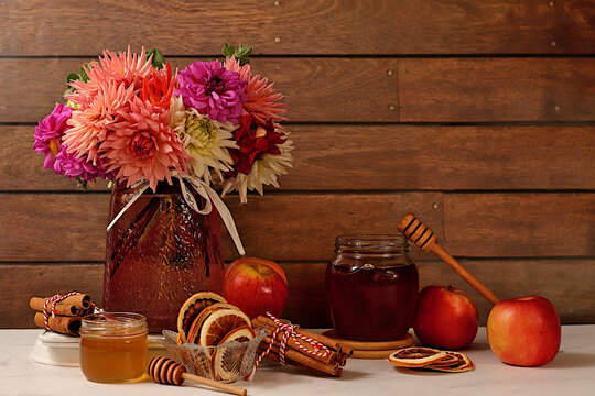 Autumn banner with a beautiful bouquet of dahlias in a vase, honey, apples, dried orange, cinnamon and star anise on an elegant background, autumn greeting and gratitude concept, cozy composition
