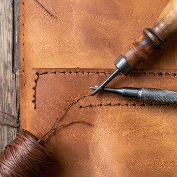 Leather crafting with stitching and tools on rustic table handmade closeup