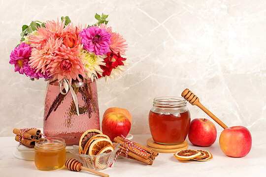 Autumn banner with a beautiful bouquet of dahlias in a vase, honey, apples, dried orange, cinnamon and star anise on an elegant background, autumn greeting and gratitude concept, cozy composition